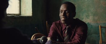 Movie still from “Empire of Light” (2022), directed by Sam Mendes – A man in a maroon shirt and a striped tie; Close Up shot, Over the shoulder angle