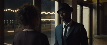 Movie still from “Empire of Light” (2022), directed by Sam Mendes – A man wearing a suit and a hat talking to a woman; Close Up shot, Over the shoulder angle