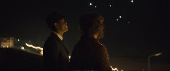 Movie still from “Empire of Light” (2022), directed by Sam Mendes – A man and a woman standing next to each other in the dark; Medium shot, Over the shoulder angle