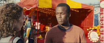 Movie still from “Empire of Light” (2022), directed by Sam Mendes – A man standing in front of a carnival tent; Close Up shot, Over the shoulder angle