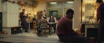 Movie still from “Empire of Light” (2022), directed by Sam Mendes – A group of people sitting around a table; Wide shot, High angle