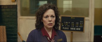 Movie still from “Empire of Light” (2022), directed by Sam Mendes – A woman with curly brown hair wearing a purple sweater; Close Up shot, Over the shoulder angle