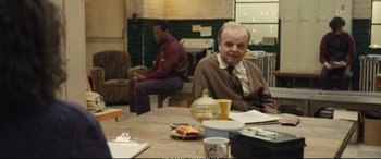 Movie still from “Empire of Light” (2022), directed by Sam Mendes – A man sitting at a table in front of another man; Medium shot, Over the shoulder angle