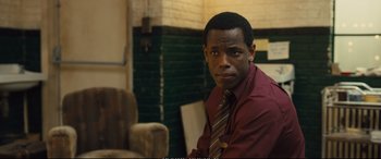 Movie still from “Empire of Light” (2022), directed by Sam Mendes – A man wearing a red shirt and a striped tie; Close Up shot, Over the shoulder angle