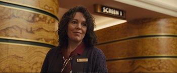 Movie still from “Empire of Light” (2022), directed by Sam Mendes – A woman standing in front of a screen 1 sign; Close Up shot, Over the shoulder angle