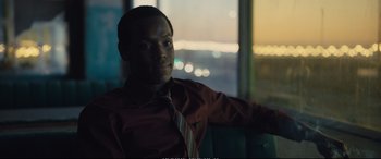 Movie still from “Empire of Light” (2022), directed by Sam Mendes – A man sitting in front of a window wearing a tie; Close Up shot, Over the shoulder angle