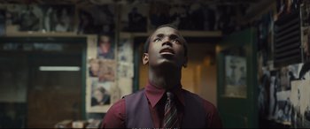 Movie still from “Empire of Light” (2022), directed by Sam Mendes – A man in a red shirt and tie looking up; Close Up shot, Low angle