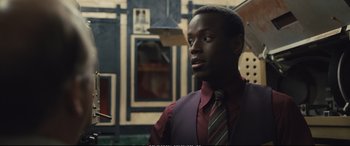 Movie still from “Empire of Light” (2022), directed by Sam Mendes – A man wearing a purple vest and a striped tie; Close Up shot, Over the shoulder angle