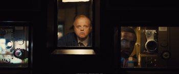 Movie still from “Empire of Light” (2022), directed by Sam Mendes – A man looking at himself in a mirror; Medium shot, Over the shoulder angle