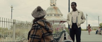 Movie still from “Empire of Light” (2022), directed by Sam Mendes – A man and a woman standing next to each other on top of a park bench; Medium shot, Over the shoulder angle