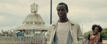 Movie still from “Empire of Light” (2022), directed by Sam Mendes – A young man standing in front of a gazebo; Close Up shot, Low angle