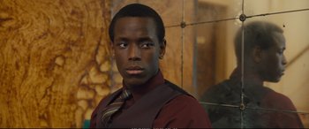 Movie still from “Empire of Light” (2022), directed by Sam Mendes – A man in a red shirt and a brown tie; Close Up shot, Over the shoulder angle