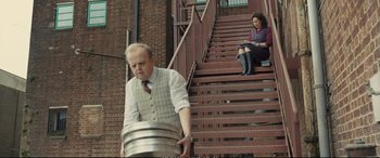 Movie still from “Empire of Light” (2022), directed by Sam Mendes – A man and a woman sitting on some stairs; Wide shot, Low angle