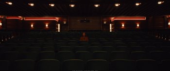 Movie still from “Empire of Light” (2022), directed by Sam Mendes – A person sitting in a theater with a lot of seats; Extreme Wide shot, High angle