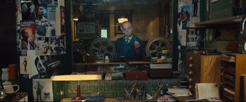 Movie still from “Empire of Light” (2022), directed by Sam Mendes – A man sitting at a table in front of a window; Medium shot, Over the shoulder angle