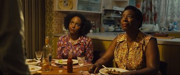 Movie still from “Empire of Light” (2022), directed by Sam Mendes – Two women sitting at a table with plates of food in front of them; Medium shot, High angle