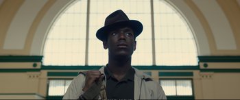 Movie still from “Empire of Light” (2022), directed by Sam Mendes – A man in a hat and a jacket looking up; Close Up shot, Low angle