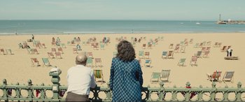 Movie still from “Empire of Light” (2022), directed by Sam Mendes – A man and a woman looking out at the beach; Wide shot, High angle