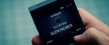 Movie still from “The Judge” (2014), directed by David Dobkin – A person holding a cell phone with a broken screen on it; Extreme Close Up shot, Overhead angle