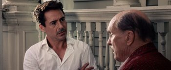 Movie still from “The Judge” (2014), directed by David Dobkin – A man talking to another man in front of a porch railing; Close Up shot, Over the shoulder angle