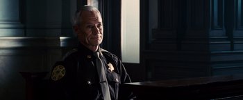Movie still from “The Judge” (2014), directed by David Dobkin – An older man in a police uniform sitting in front of a window; Medium shot, Low angle