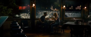 Movie still from “The Judge” (2014), directed by David Dobkin – A man and a woman sitting at a table in front of a waterfall at night; Wide shot, Over the shoulder angle