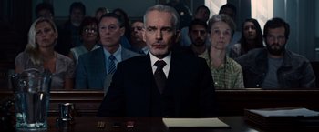 Movie still from “The Judge” (2014), directed by David Dobkin – A man sitting in front of a group of people; Medium shot, Low angle