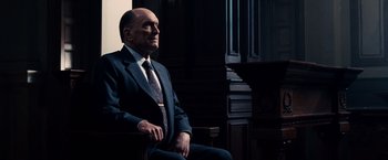 Movie still from “The Judge” (2014), directed by David Dobkin – An older man in a suit and tie sitting in front of a piano; Medium shot, Low angle
