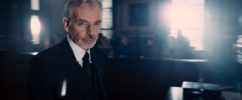 Movie still from “The Judge” (2014), directed by David Dobkin – A man in a suit and tie in front of a group of people; Close Up shot, Low angle