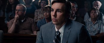 Movie still from “The Judge” (2014), directed by David Dobkin – A man wearing a suit and tie in front of a group of people; Close Up shot, Over the shoulder angle