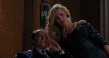 Movie still from “Batman” (1989), directed by Tim Burton – A man and a woman pose for a picture; Medium shot, Low angle