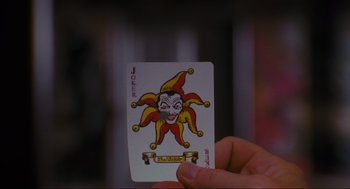 Movie still from “Batman” (1989), directed by Tim Burton – A person holding a joker playing card in their hand; Extreme Close Up shot, High angle