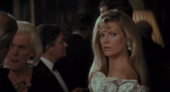 Movie still from “Batman” (1989), directed by Tim Burton – A woman in a white dress is standing in front of a man; Close Up shot, Over the shoulder angle