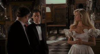Movie still from “Batman” (1989), directed by Tim Burton – Two men and a woman standing in front of each other in a room; Medium shot, Low angle