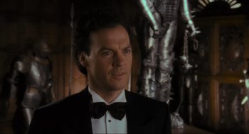 Movie still from “Batman” (1989), directed by Tim Burton – A person wearing a suit and bow tie; Close Up shot, Low angle