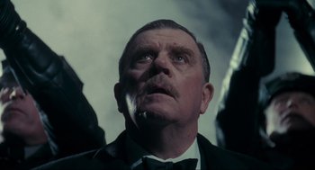 Movie still from “Batman” (1989), directed by Tim Burton – An older man in a suit looking up at the sky; Close Up shot, Low angle