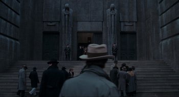Movie still from “Batman” (1989), directed by Tim Burton – A crowd of people standing on steps in front of a building; Extreme Wide shot, Low angle