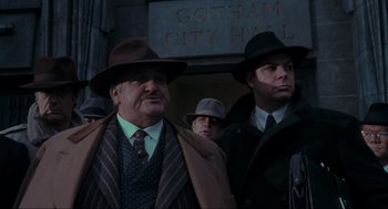 Movie still from “Batman” (1989), directed by Tim Burton – A group of men standing next to each other wearing hats; Medium shot, Low angle