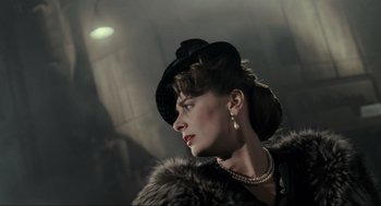 Movie still from “Batman” (1989), directed by Tim Burton – A woman wearing a hat and a fur coat; Close Up shot, Over the shoulder angle
