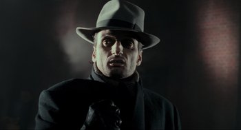 Movie still from “Batman” (1989), directed by Tim Burton – A man wearing a hat and a tie; Close Up shot, Low angle