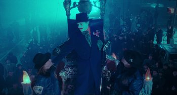 Movie still from “Batman” (1989), directed by Tim Burton – A man in a black suit and a black top hat; Wide shot, High angle