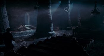 Movie still from “Batman” (1989), directed by Tim Burton – A dark room with pillars and a bench in the middle; Extreme Wide shot, High angle