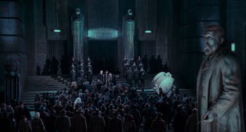 Movie still from “Batman” (1989), directed by Tim Burton – A group of people standing in front of a building; Extreme Wide shot, High angle