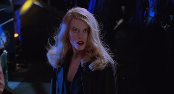 Movie still from “Batman Forever” (1995), directed by Joel Schumacher – A woman with long blonde hair wearing a black jacket; Close Up shot, Low angle