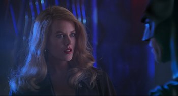 Movie still from “Batman Forever” (1995), directed by Joel Schumacher – A woman with blonde hair and red lipstick looking to her left; Close Up shot, Over the shoulder angle