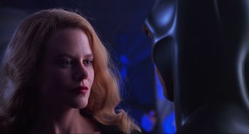 Movie still from “Batman Forever” (1995), directed by Joel Schumacher – A woman with blonde hair stares at a man in a batman costume; Close Up shot, Over the shoulder angle