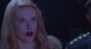 Movie still from “Batman Forever” (1995), directed by Joel Schumacher – A person with long blonde hair; Close Up shot, Low angle