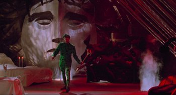 Movie still from “Batman Forever” (1995), directed by Joel Schumacher – A man in a green suit is holding a sword; Wide shot, Low angle