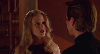 Movie still from “Batman Forever” (1995), directed by Joel Schumacher – A woman with long blonde hair looking at a man in a black shirt; Close Up shot, Over the shoulder angle