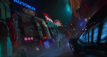 Movie still from “Batman Forever” (1995), directed by Joel Schumacher – A car driving down a street at night time; Wide shot, Low angle